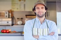 Small business owner smiling in front of his takeaway food franchise business owner satisfaction